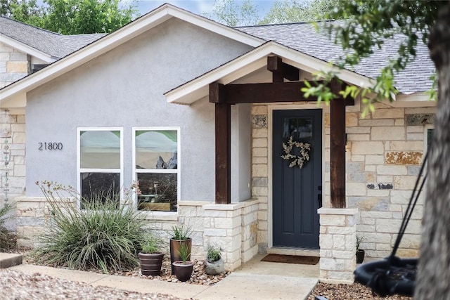 21800 Owens Cv, Lago Vista, TX 78645 - doorway to property with stone siding, a shingled roof, and stucco siding