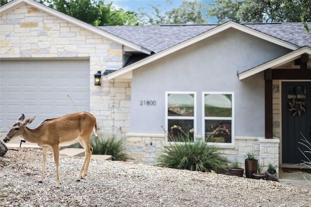 21800 Owens Cv, Lago Vista, TX 78645 - view of front of property with stone siding, roof with shingles, a garage, and stucco siding