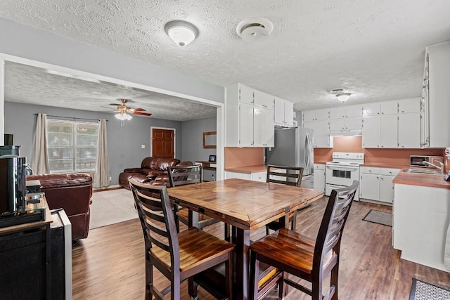 237 Oak Park Two, Rockdale, TX 76567 - dining room featuring wood finished floors, ceiling fan, and a textured ceiling