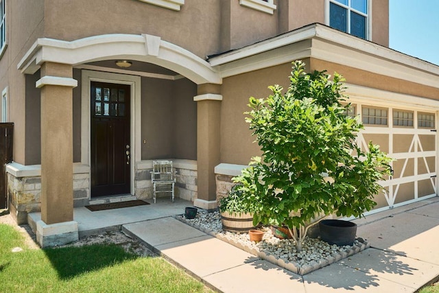 144 Holstein St, Hutto, TX 78634 - property entrance featuring stone siding, stucco siding, and a garage