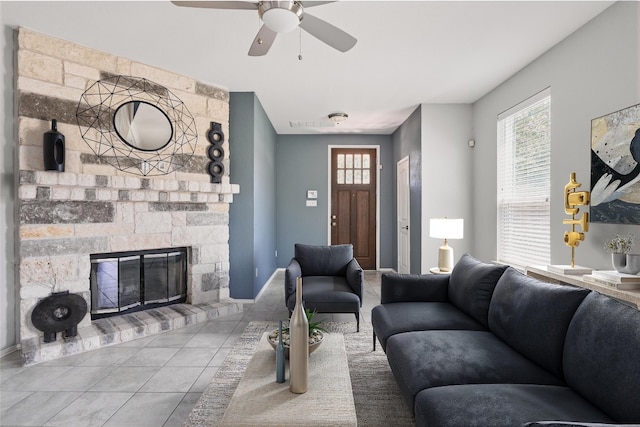 144 Holstein St, Hutto, TX 78634 - tiled living area with a ceiling fan, healthy amount of natural light, and a stone fireplace
