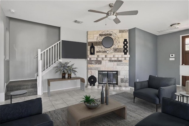 144 Holstein St, Hutto, TX 78634 - tiled living area with a ceiling fan, stairs, and a stone fireplace