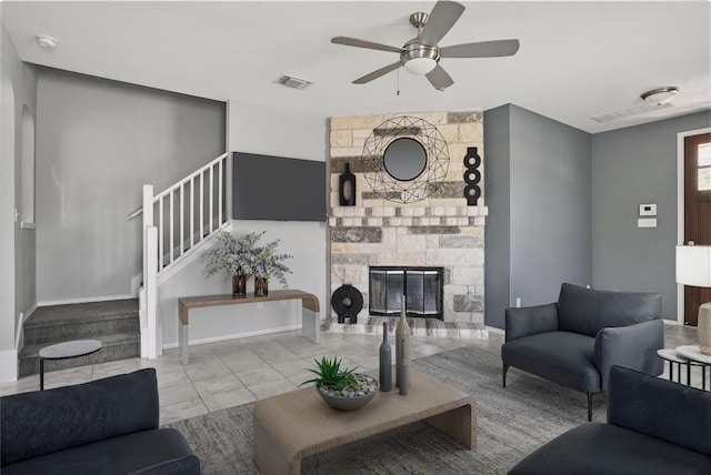 144 Holstein St, Hutto, TX 78634 - tiled living room featuring stairs, ceiling fan, and a stone fireplace