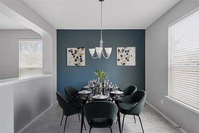 144 Holstein St, Hutto, TX 78634 - tiled dining room with an accent wall and a chandelier