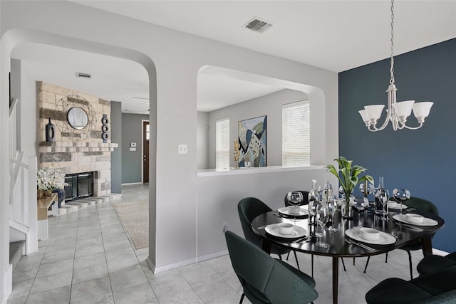 144 Holstein St, Hutto, TX 78634 - tiled dining room featuring a chandelier and a stone fireplace