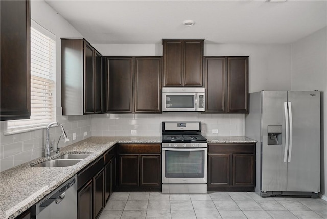 144 Holstein St, Hutto, TX 78634 - kitchen featuring stainless steel appliances, dark brown cabinets, decorative backsplash, light stone countertops, and healthy amount of natural light