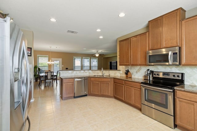 18401 Pencil Cactus Dr, Pflugerville, TX 78660 - kitchen featuring stainless steel appliances, tasteful backsplash, recessed lighting, a peninsula, and light stone countertops