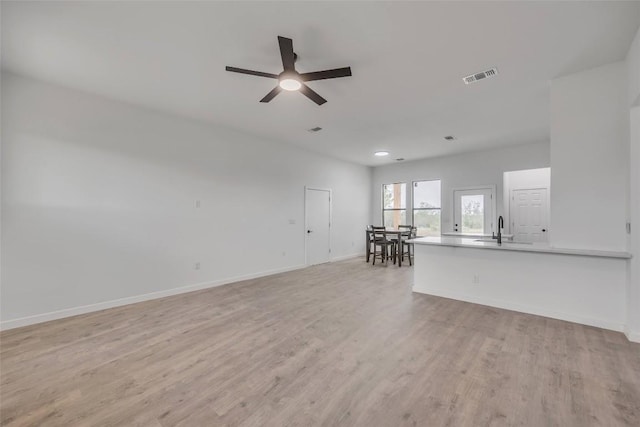 138 Blushing Dr, Cedar Creek, TX 78612 - unfurnished living room with a sink, light wood-type flooring, a ceiling fan, baseboards, and recessed lighting