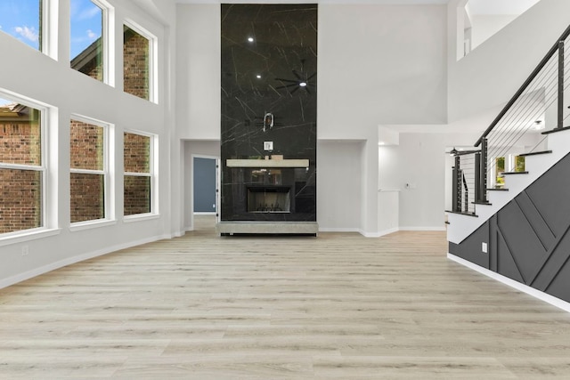 210 Las Colinas Dr, Georgetown, TX 78628 - unfurnished living room featuring a high ceiling, stairs, baseboards, wood finished floors, and healthy amount of natural light