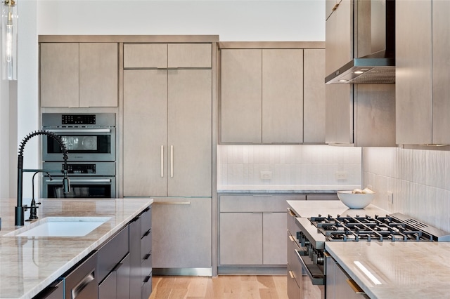120 July Johnson Dr, Austin, TX 78737 - kitchen with range, wall chimney range hood, light stone counters, stainless steel double oven, and decorative backsplash