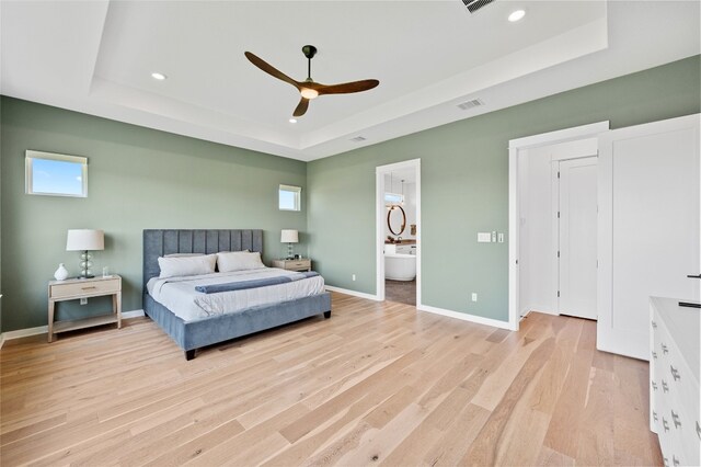 120 July Johnson Dr, Austin, TX 78737 - bedroom featuring a tray ceiling, light wood-type flooring, recessed lighting, connected bathroom, and a ceiling fan