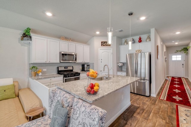 19413 Abigail Fillmore Rd, Manor, TX 78653 - kitchen featuring appliances with stainless steel finishes, a sink, white cabinets, light wood-style floors, and tasteful backsplash