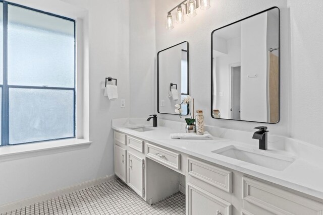 1706 Prairie Hen Cv, Austin, TX 78758 - full bath with double vanity, tile patterned flooring, and baseboards