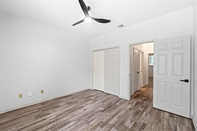1706 Prairie Hen Cv, Austin, TX 78758 - unfurnished bedroom featuring wood finished floors, a closet, ceiling fan, and baseboards