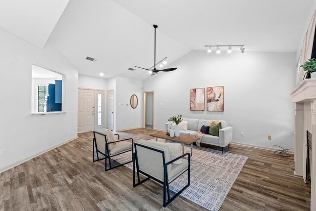 1706 Prairie Hen Cv, Austin, TX 78758 - living room with wood finished floors, a fireplace, a ceiling fan, high vaulted ceiling, and baseboards