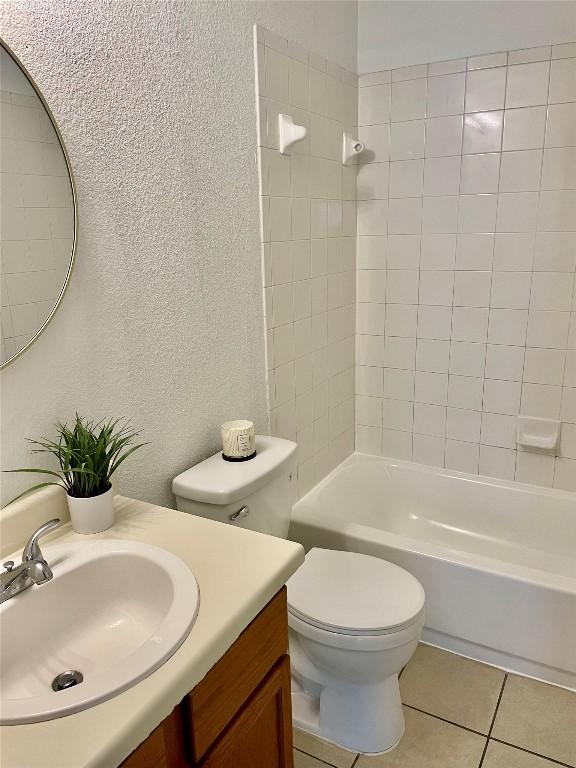 8520 Chick Pea Ln, Austin, TX 78748 - full bathroom featuring a textured wall, vanity, toilet, tile patterned floors, and shower / bath combination