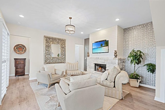19506 Inverness Dr, Lakeway, TX 78669 - living room featuring baseboards, a lit fireplace, light wood-type flooring, a chandelier, and recessed lighting