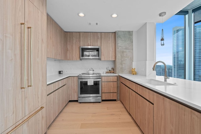 360 Nueces St Unit 1811, Austin, TX 78701 - kitchen with appliances with stainless steel finishes, a sink, light countertops, light wood-style flooring, and recessed lighting