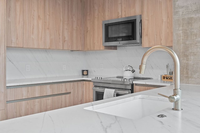 360 Nueces St Unit 1811, Austin, TX 78701 - kitchen with stainless steel microwave, modern cabinets, light brown cabinetry, backsplash, and light stone countertops