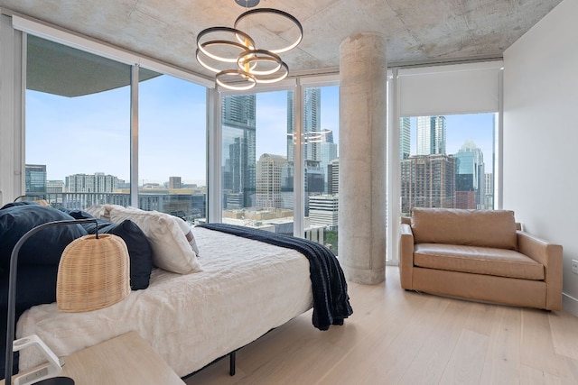 360 Nueces St Unit 1811, Austin, TX 78701 - bedroom featuring a view of skyline, wood finished floors, floor to ceiling windows, and a chandelier