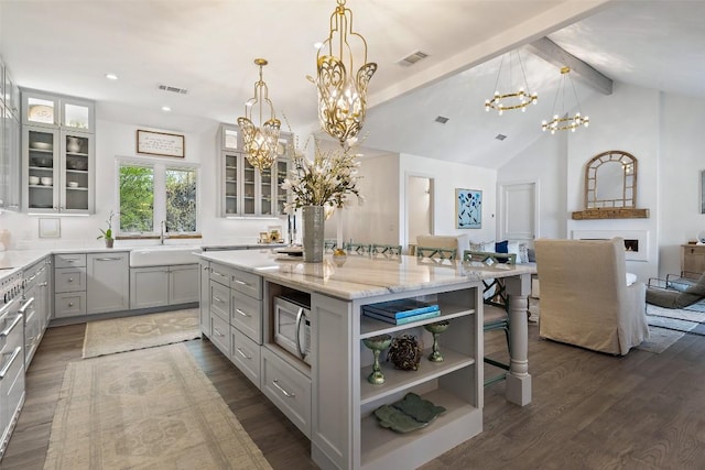 2449 Crosswind Dr, Lakeway, TX 78669 - kitchen with a chandelier, a sink, white microwave, a center island, and light stone countertops