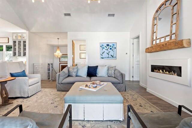 2449 Crosswind Dr, Lakeway, TX 78669 - living area featuring lofted ceiling, wood finished floors, a warm lit fireplace, and baseboards