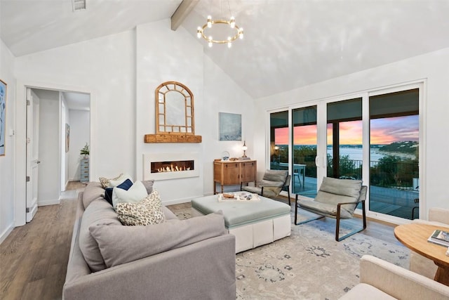 2449 Crosswind Dr, Lakeway, TX 78669 - living area with high vaulted ceiling, a chandelier, a lit fireplace, wood finished floors, and beamed ceiling