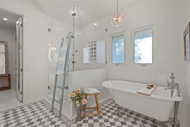 2449 Crosswind Dr, Lakeway, TX 78669 - bathroom with a tile shower, a freestanding tub, tile walls, and tile patterned floors