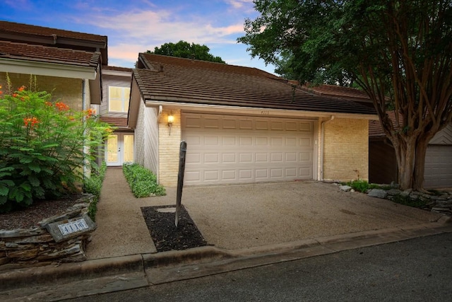 4116 Creek Ledge Unit 108, Austin, TX 78731 - view of front facade with brick siding, driveway, an attached garage, and a tile roof