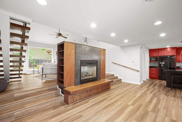 4116 Creek Ledge Unit 108, Austin, TX 78731 - unfurnished living room featuring stairway, light wood-style floors, a tiled fireplace, recessed lighting, and ceiling fan