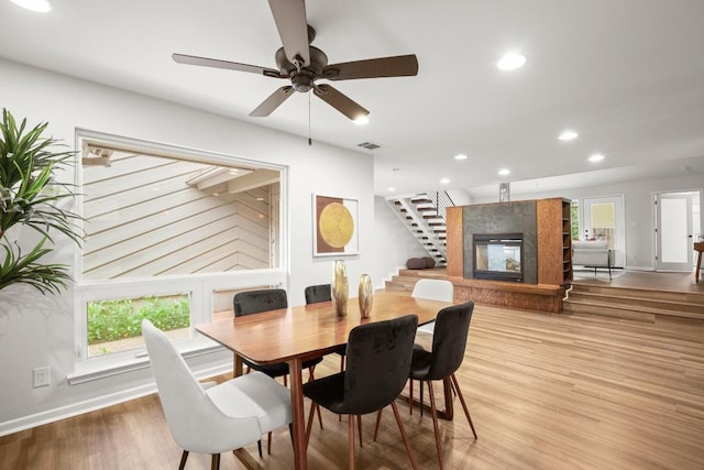 4116 Creek Ledge Unit 108, Austin, TX 78731 - dining area featuring stairway, a glass covered fireplace, light wood-style flooring, recessed lighting, and baseboards