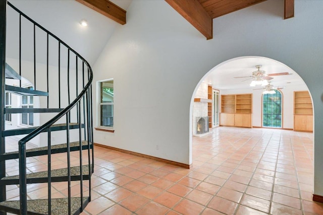 9438 Circle Dr, Austin, TX 78736 - stairway with arched walkways, a ceiling fan, beamed ceiling, tile patterned flooring, and baseboards