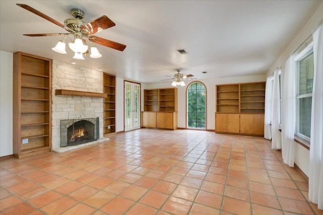 9438 Circle Dr, Austin, TX 78736 - unfurnished living room featuring built in features, light tile patterned flooring, baseboards, and a fireplace