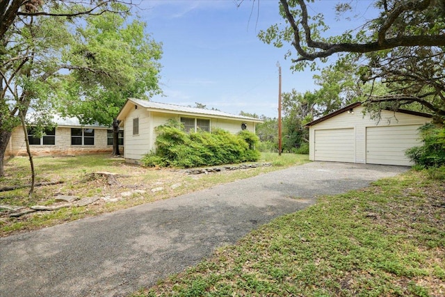 9438 Circle Dr, Austin, TX 78736 - view of front facade featuring an outbuilding, a garage, and metal roof