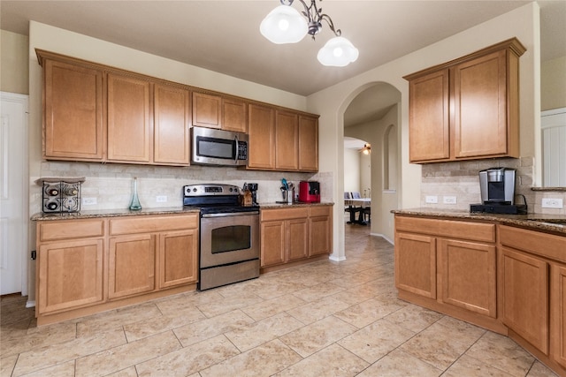 107 Marklawn Ln, Hutto, TX 78634 - kitchen with stainless steel appliances, arched walkways, tasteful backsplash, and light stone countertops