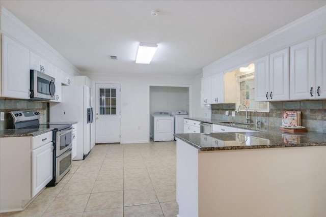 9504 Flintrock Cir, Austin, TX 78737 - kitchen featuring appliances with stainless steel finishes, independent washer and dryer, a sink, tasteful backsplash, and white cabinetry