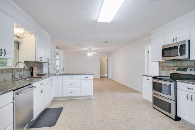 9504 Flintrock Cir, Austin, TX 78737 - kitchen with appliances with stainless steel finishes, a sink, decorative backsplash, white cabinetry, and a peninsula