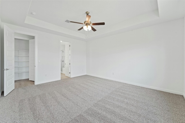 632 Deerpath St, Leander, TX 78641 - unfurnished bedroom featuring a tray ceiling, carpet floors, a spacious closet, baseboards, and ceiling fan