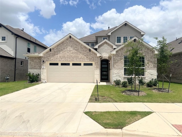 632 Deerpath St, Leander, TX 78641 - view of front of house featuring an attached garage, driveway, a front yard, and stone siding