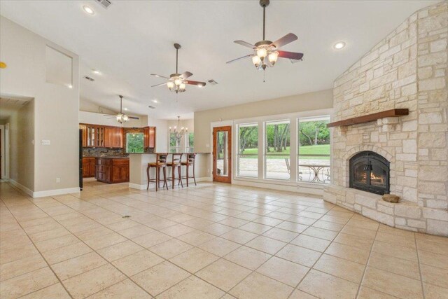 2105 Red Rock Dr, Belton, TX 76513 - unfurnished living room with vaulted ceiling, a ceiling fan, light tile patterned floors, a fireplace, and a chandelier
