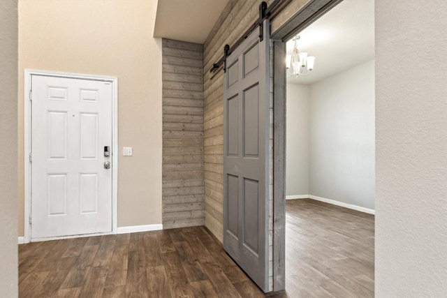 1008 Comal Run, Hutto, TX 78634 - foyer entrance featuring a barn door, dark wood finished floors, baseboards, and a chandelier