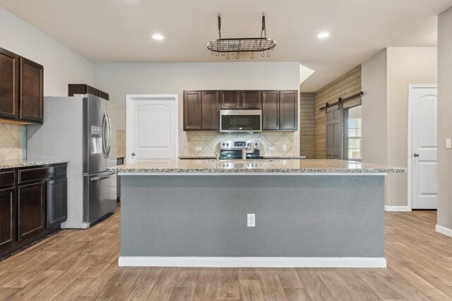 1008 Comal Run, Hutto, TX 78634 - kitchen featuring stainless steel appliances, decorative backsplash, light stone counters, and recessed lighting