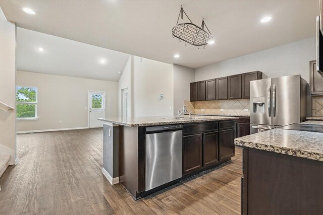 1008 Comal Run, Hutto, TX 78634 - kitchen with appliances with stainless steel finishes, dark wood-type flooring, backsplash, dark brown cabinetry, and recessed lighting