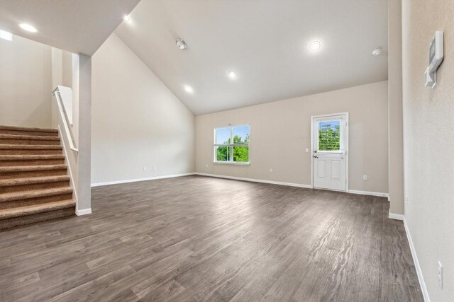 1008 Comal Run, Hutto, TX 78634 - unfurnished living room featuring wood finished floors, stairway, recessed lighting, baseboards, and high vaulted ceiling
