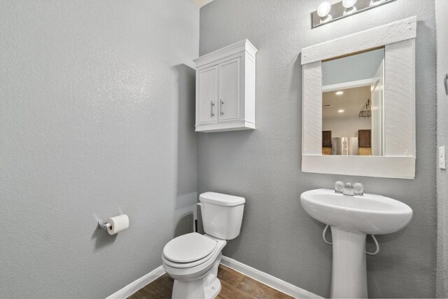 1008 Comal Run, Hutto, TX 78634 - bathroom with wood finished floors, toilet, and baseboards
