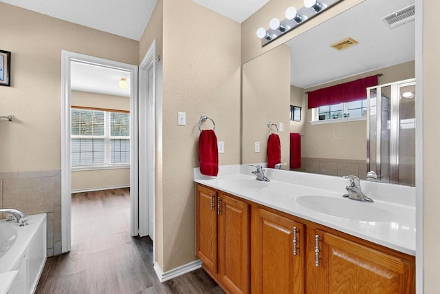 952 Hometown Pkwy, Kyle, TX 78640 - full bath with a garden tub, wood finished floors, double vanity, and a shower stall