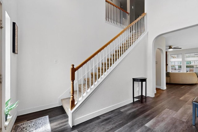 952 Hometown Pkwy, Kyle, TX 78640 - stairway featuring arched walkways, a ceiling fan, wood finished floors, and a high ceiling