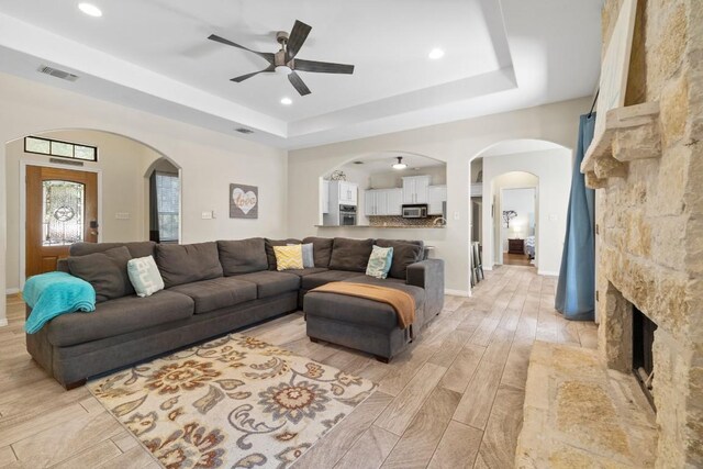 15100 General Williamson Dr, Austin, TX 78734 - living room featuring a ceiling fan, a tray ceiling, light wood-type flooring, arched walkways, and recessed lighting
