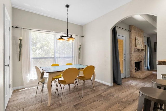 15100 General Williamson Dr, Austin, TX 78734 - dining area featuring wood finished floors, arched walkways, a fireplace, and baseboards