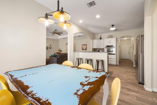 15100 General Williamson Dr, Austin, TX 78734 - dining space with arched walkways, light wood-style flooring, a ceiling fan, recessed lighting, and baseboards